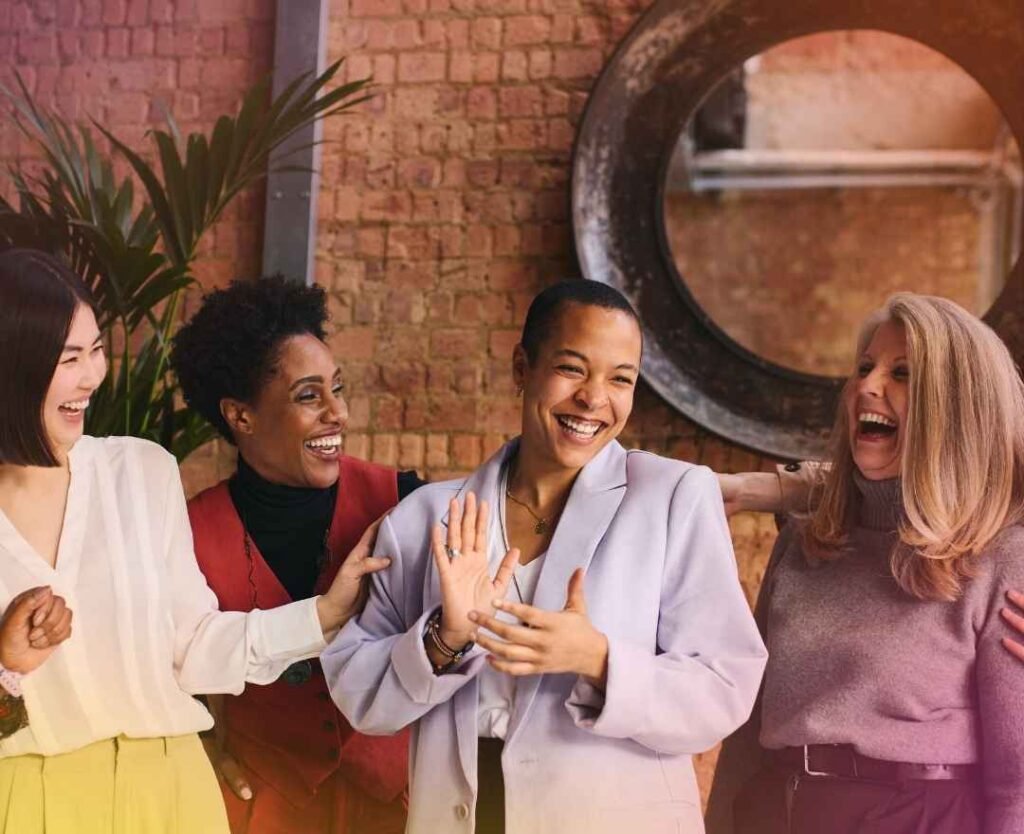 a group of professional women standing in front of a brick wall enjoying a chat | When Empaths Pursue Purpose | The Vital Spirit | Laura Rowe | Empath Mentor