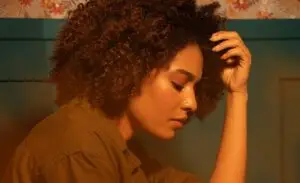 Young woman with curly hair looking pensive | The Vital Spirit | Laura Rowe | Empath Mentor